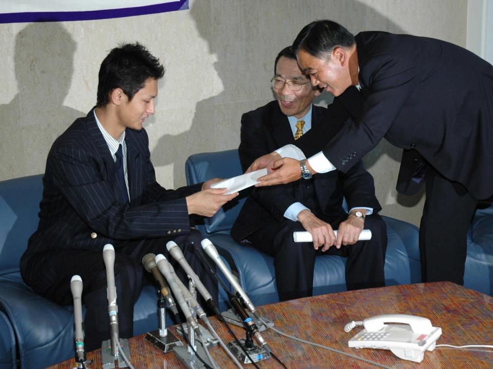 　ヒルマン監督からのメッセージを今成スカウト（右）から受け取る東北高・ダルビッシュ＝２００４年１１月