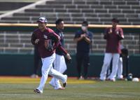 　試合前の練習を終え投手陣から拍手で送り出される開幕投手の則本（手前）＝撮影・開出牧