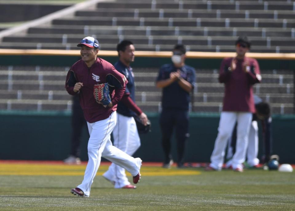 　試合前の練習を終え投手陣から拍手で送り出される開幕投手の則本（手前）＝撮影・開出牧
