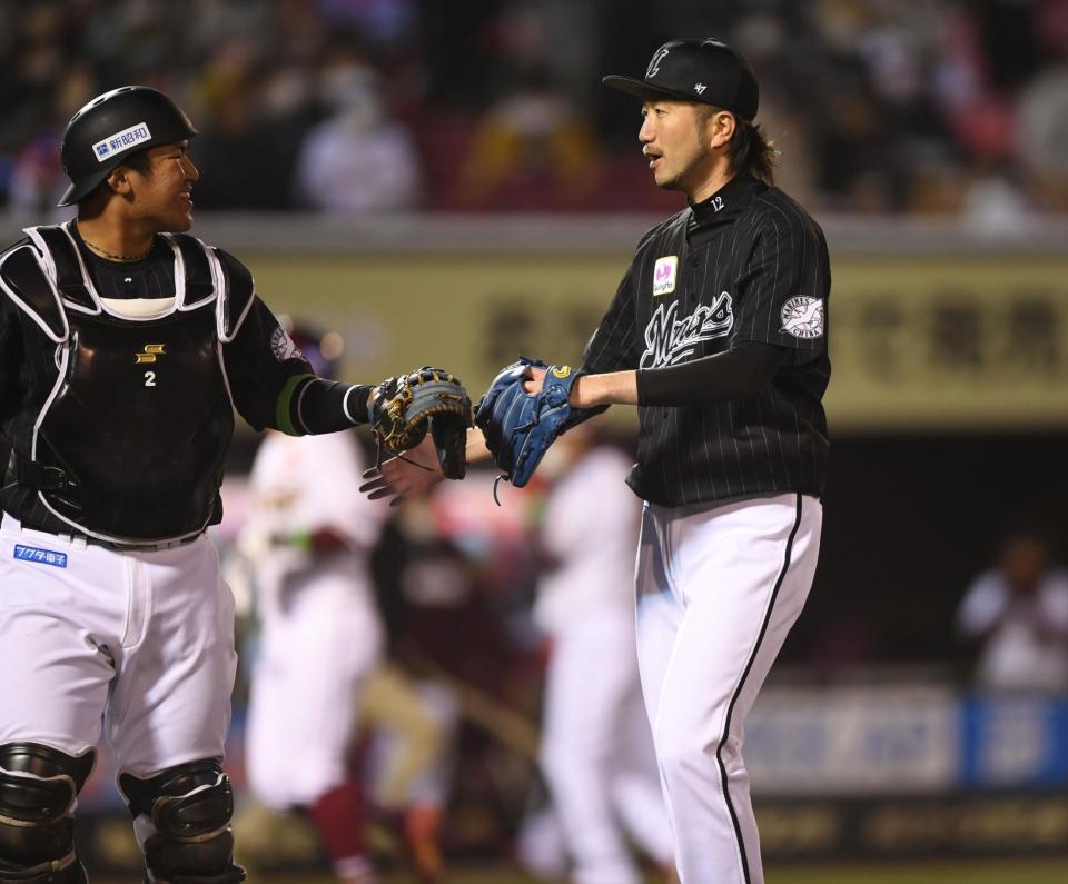 　７回、鈴木大を左飛に打ち取り、松川（左）とタッチをかわす石川（撮影・開出牧）