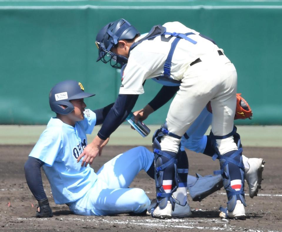 　５回、死球を左足に受け起き上がろうとする近江・山田（左）を手助けする浦和学院・高山（撮影・伊藤笙子）