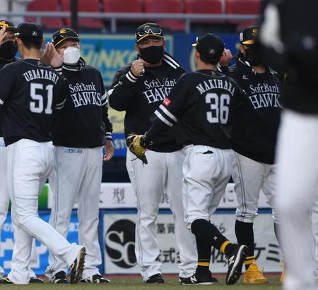 　開幕６連勝しナインとタッチを交わす藤本監督（中央）＝撮影・開出牧