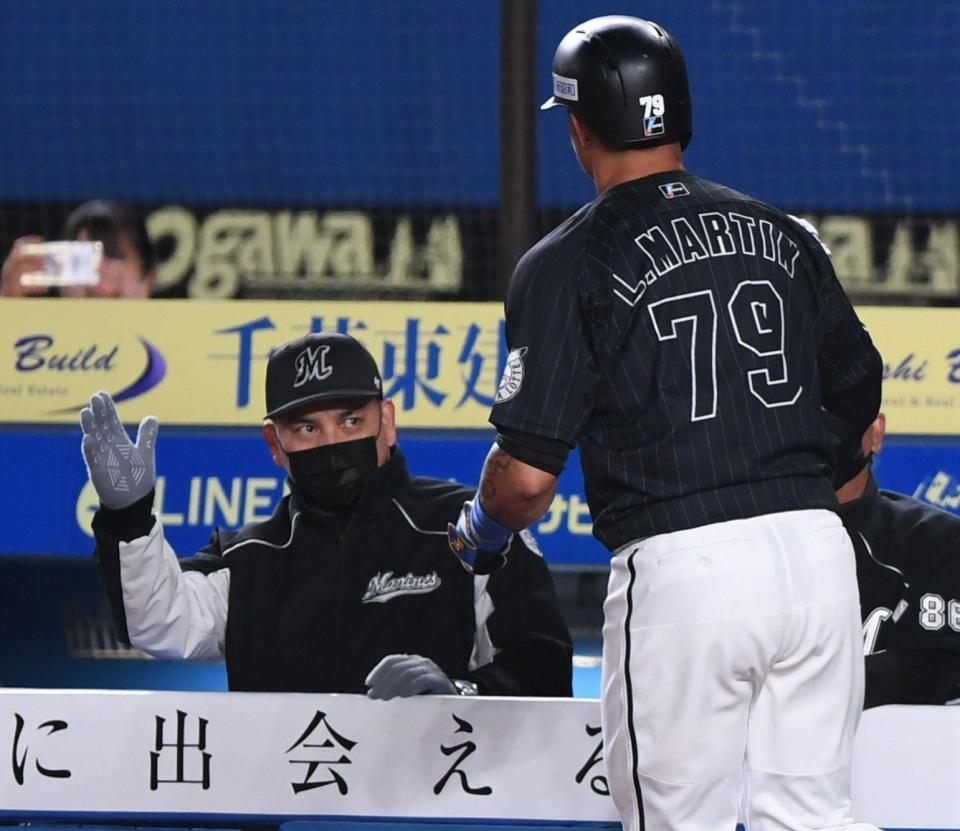 　７回、先制の右越え２ランを放ったマーティン（手前）とタッチを交わすロッテ・井口監督（撮影・開出牧）