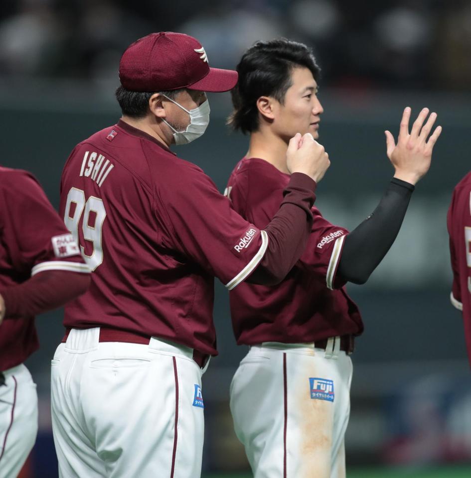 　試合に勝利し、楽天・西川（右）とともにナインを迎える石井監督（撮影・中島達哉）
