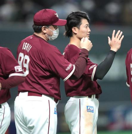 　試合後、石井監督（左）とともにナインを迎える西川