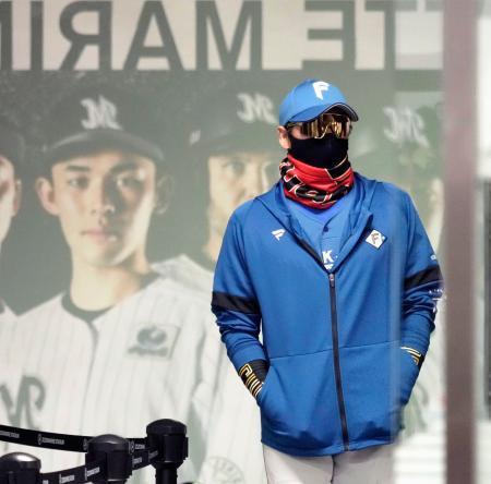 　練習を終え、引き揚げる日本ハム・新庄監督。後方はロッテ選手のポスターの佐々木朗＝１５日、ＺＯＺＯマリン