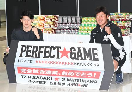 完全試合を祝うボードを手にガッツポーズする佐々木朗（左）と松川（撮影・高石航平）