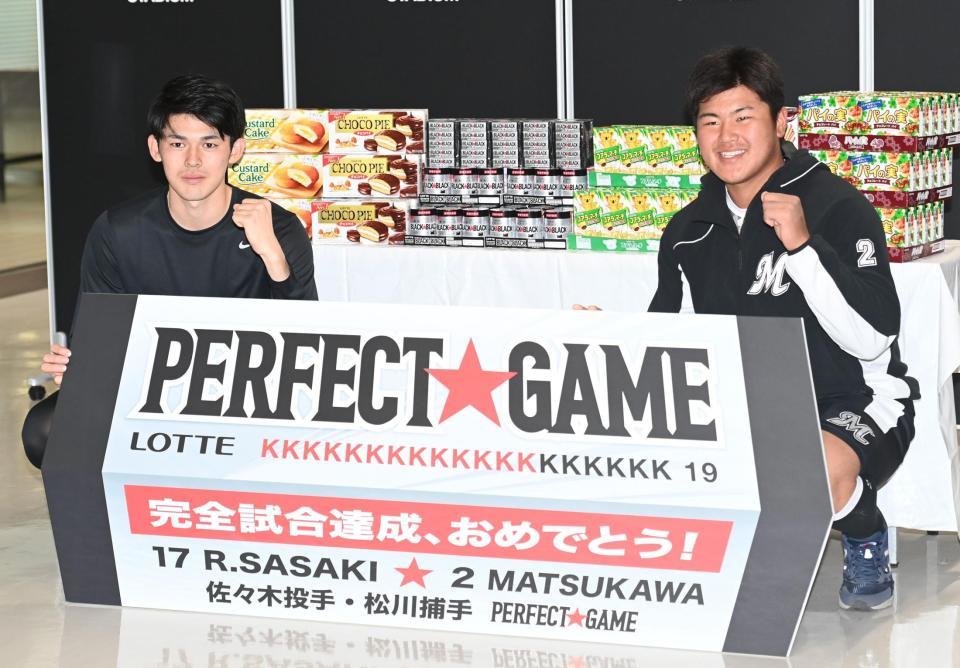 完全試合を祝うボードを手にガッツポーズする佐々木朗（左）と松川（撮影・高石航平）