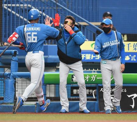 　１０回、先制の中越えソロ放った万波（手前）とタッチを交わす新庄ビッグボス（中央）＝撮影・開出牧