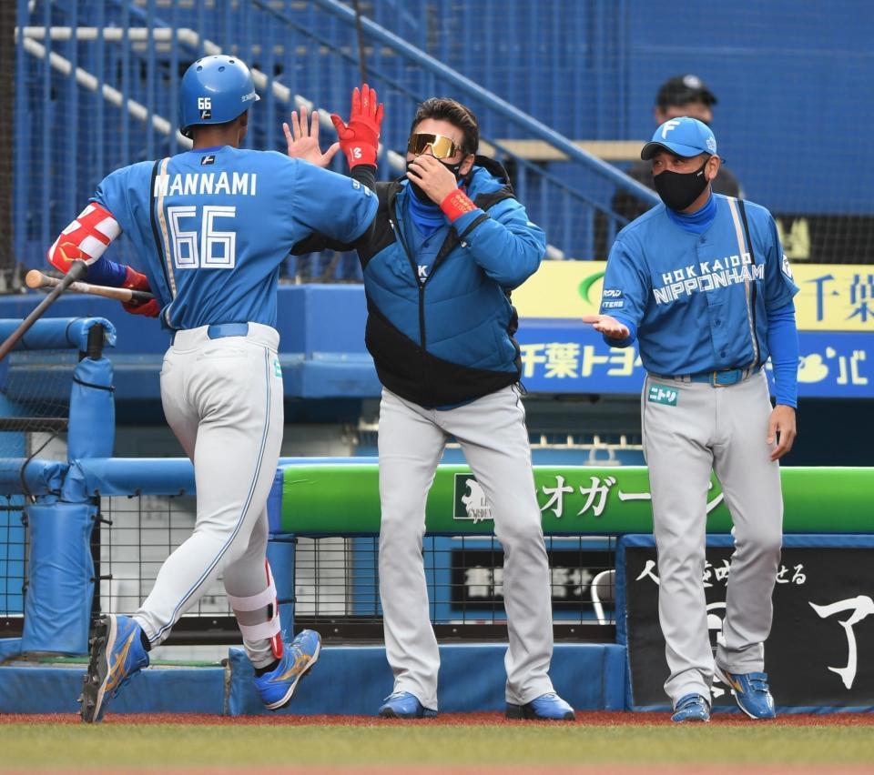 　１０回、先制の中越えソロ放った万波（手前）とタッチを交わす新庄ビッグボス（中央）＝撮影・開出牧