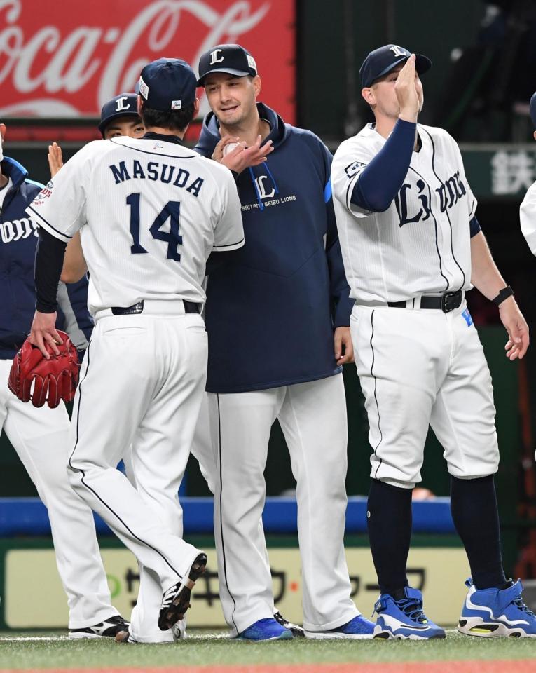 　来日初先発初勝利を挙げ、増田（左）からウイニングボールを受け取るスミス（中）＝撮影・佐藤厚