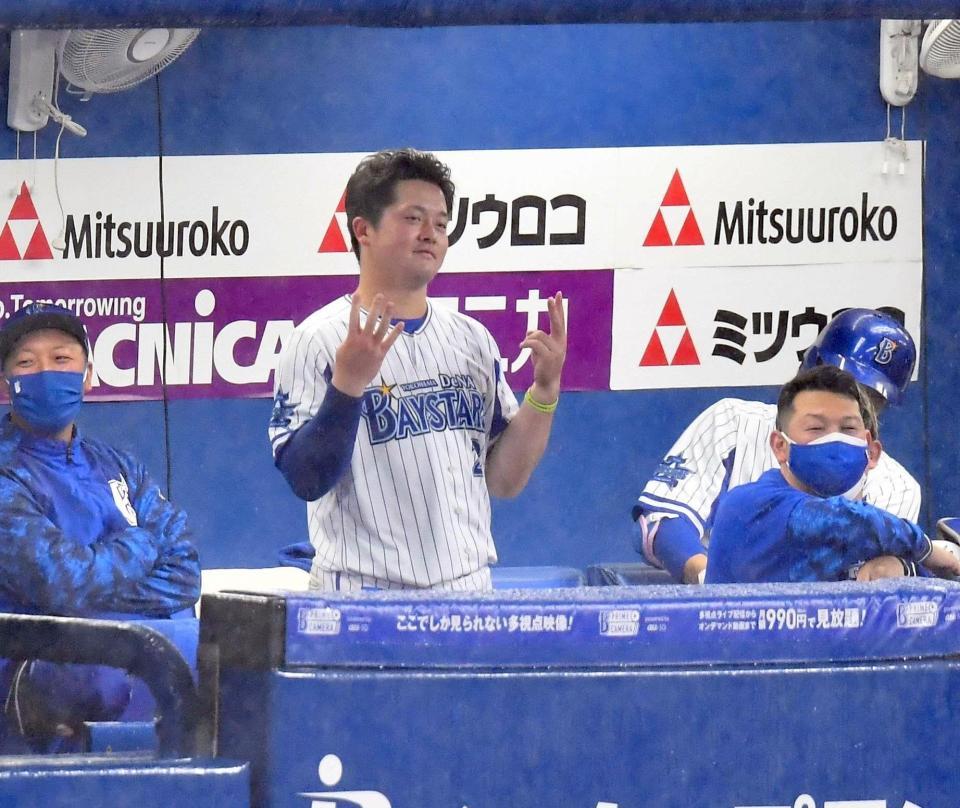 　降雨中断中、ベンチで応援団の音楽に合わせて踊る牧（撮影・西岡正）