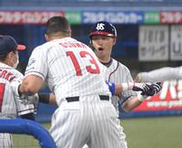 　４回、先制ソロを放ちオスナに迎えられる青木（撮影・金田祐二）