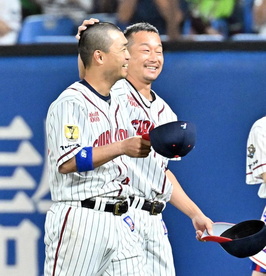 　２１年連続勝利を挙げ、青木（左）の頭を撫でる石川