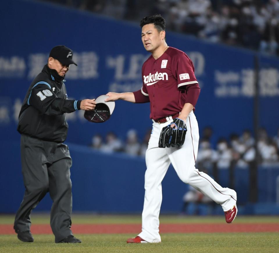 飛ばされた帽子を塁審から受け取る先発の田中将（撮影・三好信也）