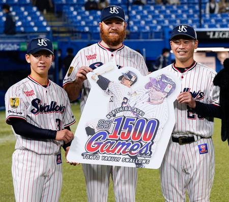 試合終了後、青木（右）の通算１５００試合出場の記念ボードを手に笑顔を見せるの内山壮（左）、サイスニード