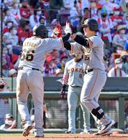 　６回、同点３ランを放って生還し、香月（左）と笑顔でタッチを交わす岡本和（撮影・立川洋一郎）