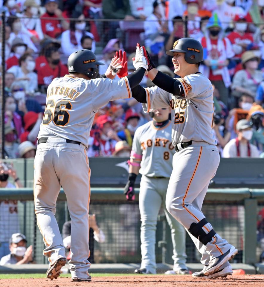　６回、同点３ランを放って生還し、香月（左）と笑顔でタッチを交わす岡本和（撮影・立川洋一郎）