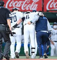 　３回、自打球が足に当たりコーチらに担がれてベンチに戻る源田（撮影・高石航平）