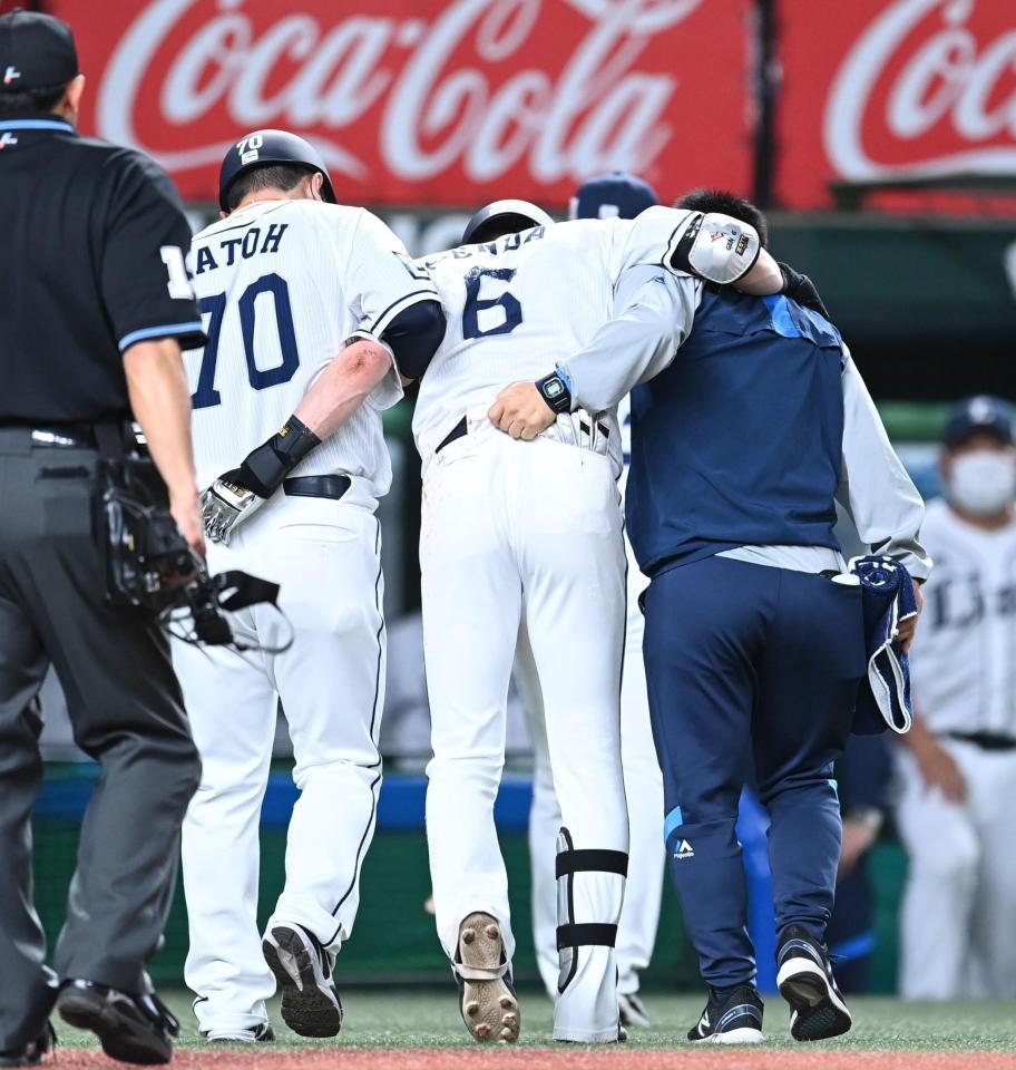 　３回、自打球が足に当たりコーチらに担がれてベンチに戻る源田（撮影・高石航平）