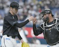 　６回、相手チームに得点を許さず投げ終え、松川（右）とタッチをかわす佐々木朗（撮影・石井剣太郎）