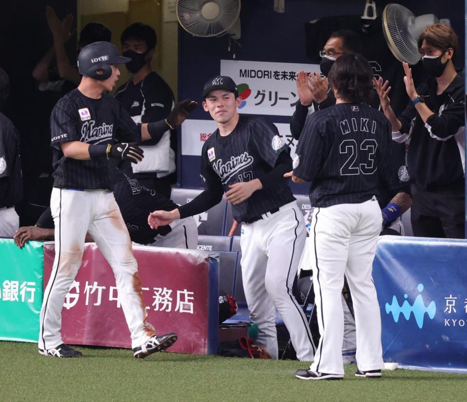 　８回、佐藤のスクイズで生還した高部を迎える佐々木朗（撮影・坂部計介）