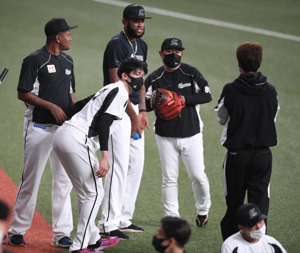 　練習前にロメロ（左）らと談笑する佐々木朗（左から２人目）＝撮影・石井剣太郎