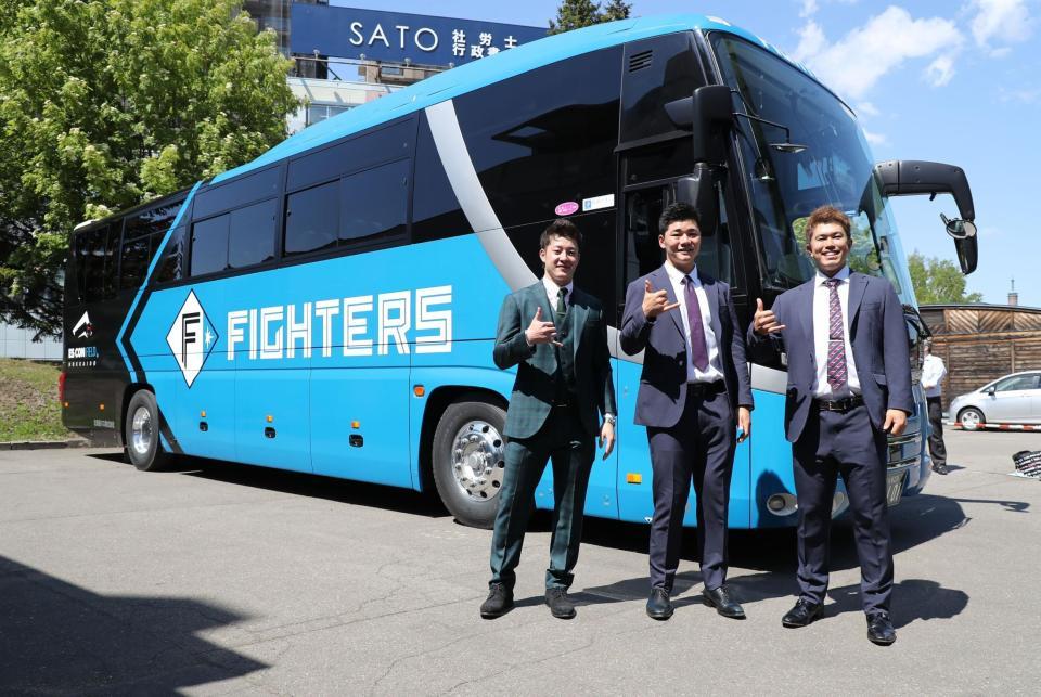 　新チームバスを背にビッグボスポーズをする（左から）吉田、清宮、今川（撮影・中島達哉）