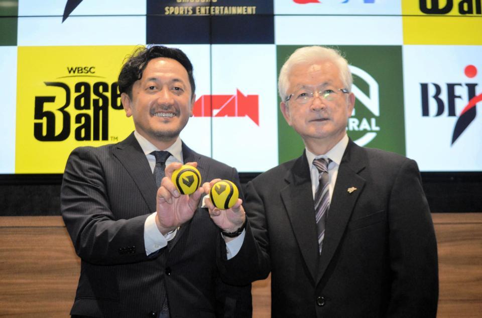 「ベースボール５」の公式球を持って記念撮影する株式会社アマダナスポーツエンタテインメントの熊本社長と全日本野球協会の山中会長（右）＝東京都新宿区