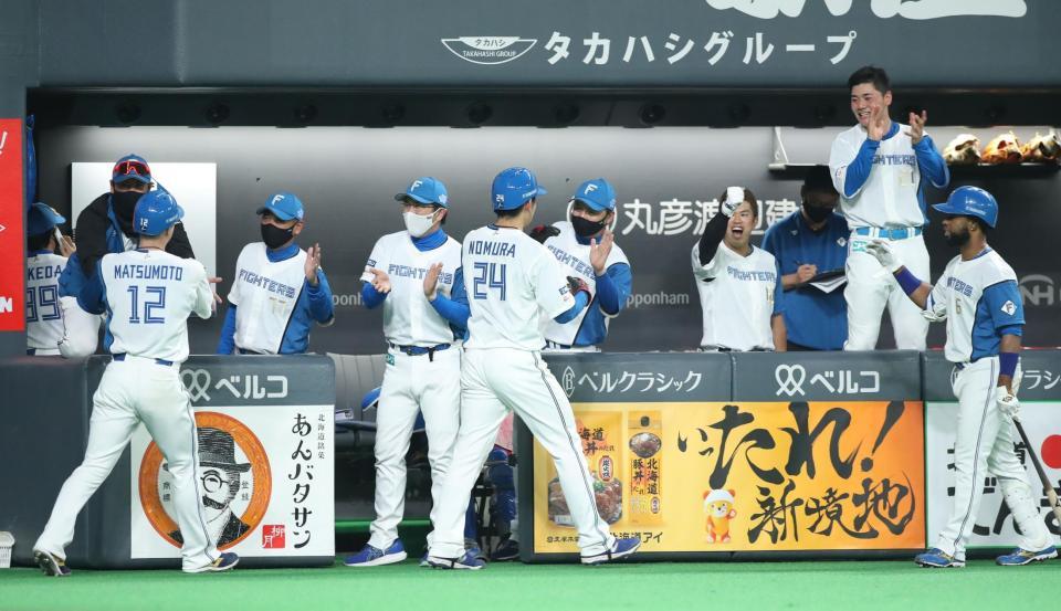 ７回、宇佐見真吾の適時二塁打で生還した松本剛（手前左）らを迎える新庄剛志ビッグボス（左端）＝札幌ドーム（撮影・中島達哉）