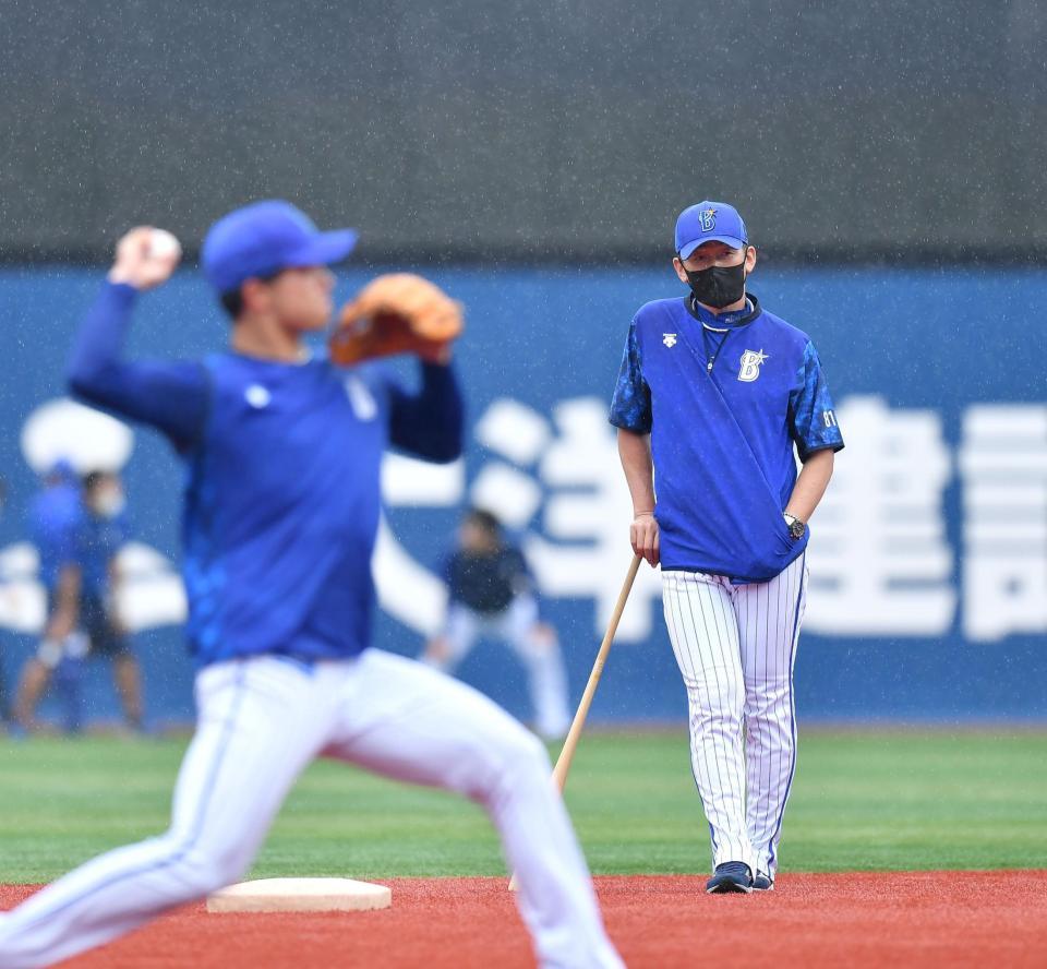 　雨の中、練習を見る三浦監督（右）＝撮影・西岡正