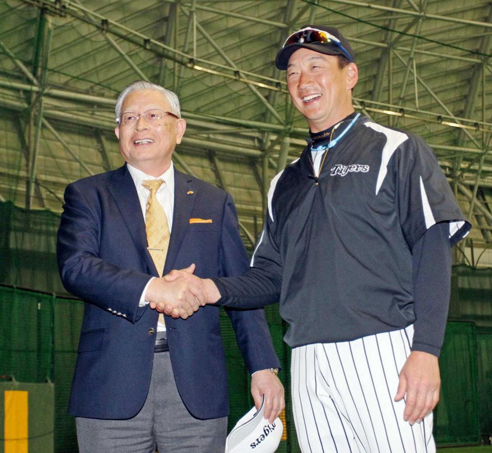 　握手を交わす熊崎コミッショナー（左）と金本監督＝２０１６年２月２３日、宜野座