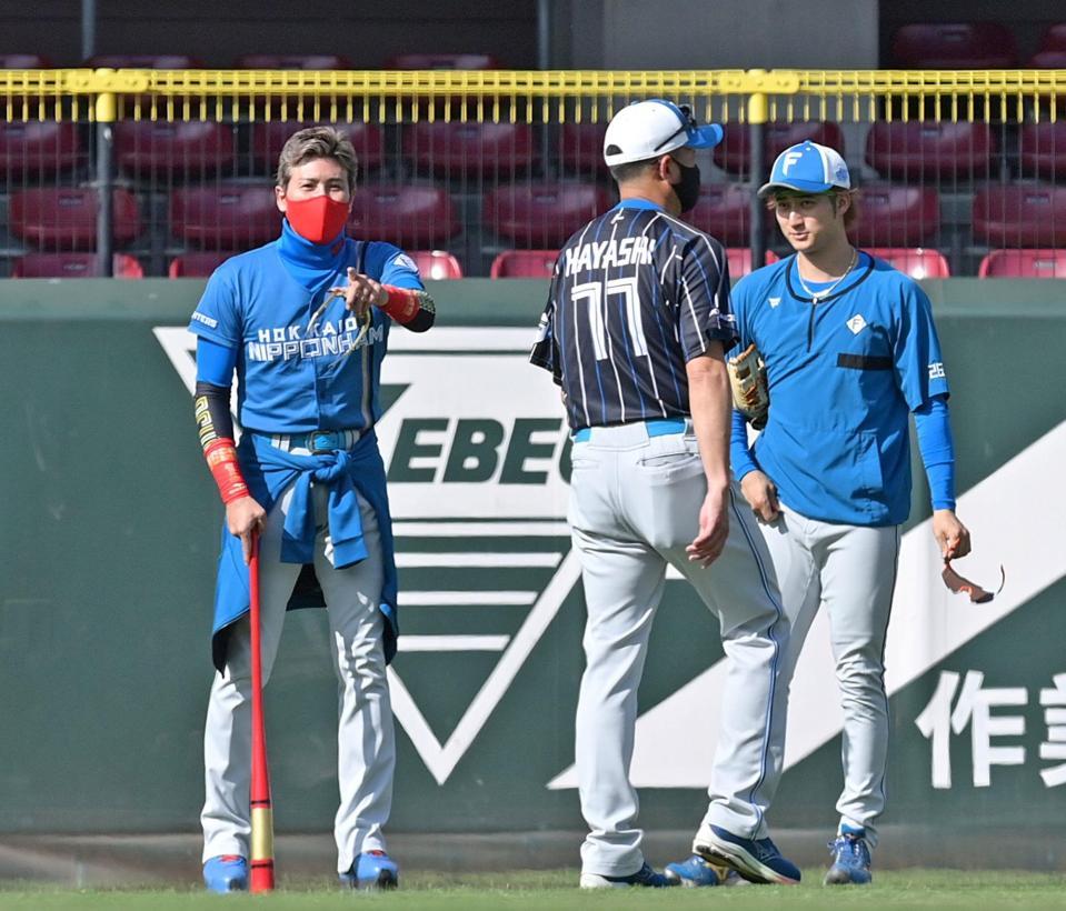 　練習中に外野を歩いてグラウンドをチェックし、浅間（右）と話をするする新庄ビッグボス（左）＝撮影・立川洋一郎