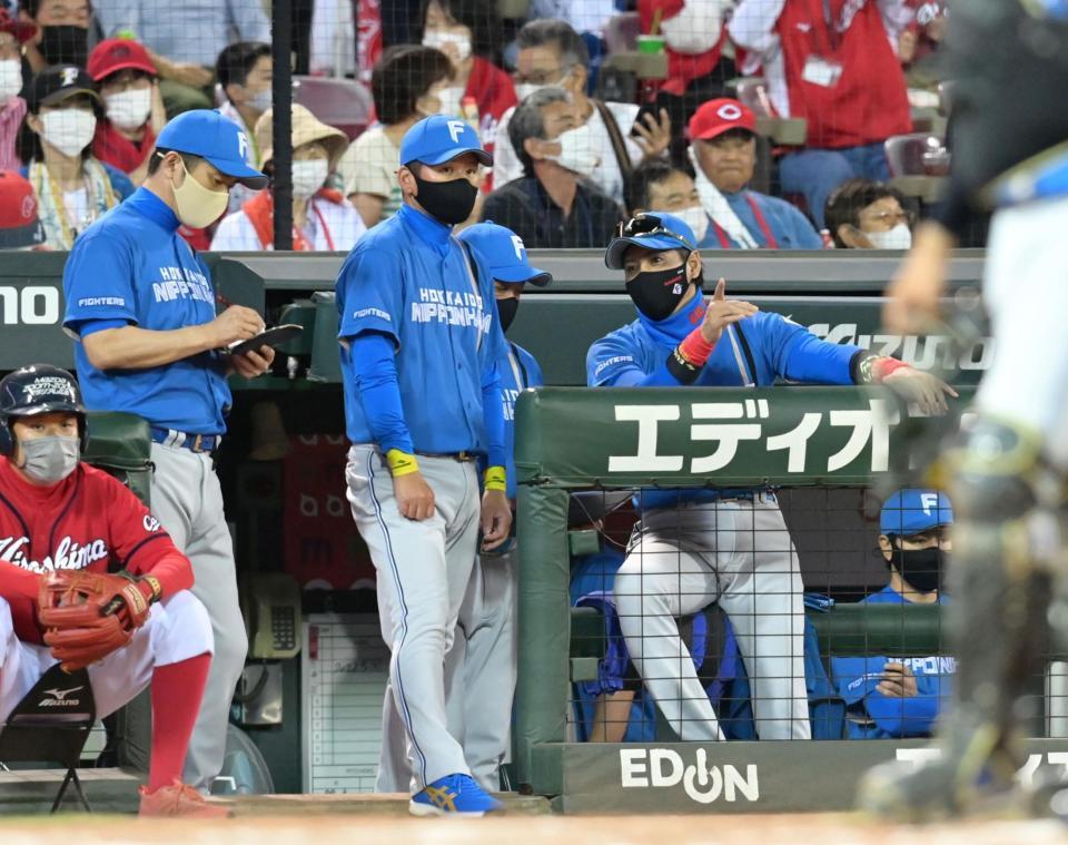 ８回、菊池涼の左犠飛で先制を許し、コーチ陣と話をする新庄ビッグボス（右端）＝撮影・立川洋一郎