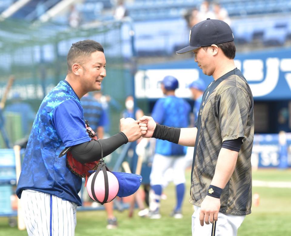 　試合前、嶺井（左）に近寄りグータッチする伏見（撮影・伊藤笙子）