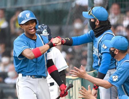 　３回、１０号ソロを放ち新庄ビッグボス（右）とタッチをかわす万波（撮影・飯室逸平）