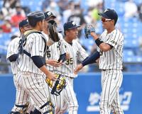 　仏教大に勝利し、ナインとタッチを交わす上武大・島村大樹（右）＝撮影・西岡正