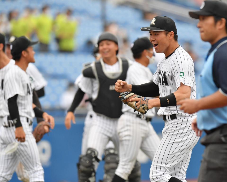 　東日本国際大に勝利し、ナインと喜び合う亜大・藤江亮太（右）＝撮影・西岡正