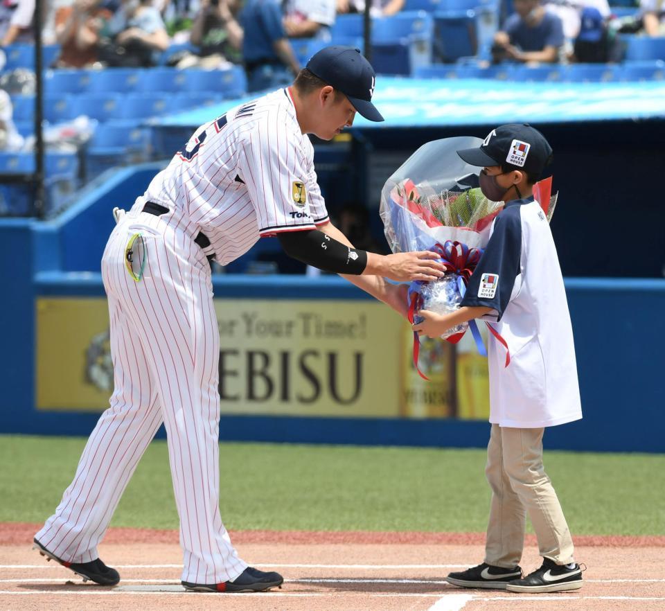 交流戦ＭＶＰに輝き祝福の花束をもらう村上（左）＝撮影・三好信也