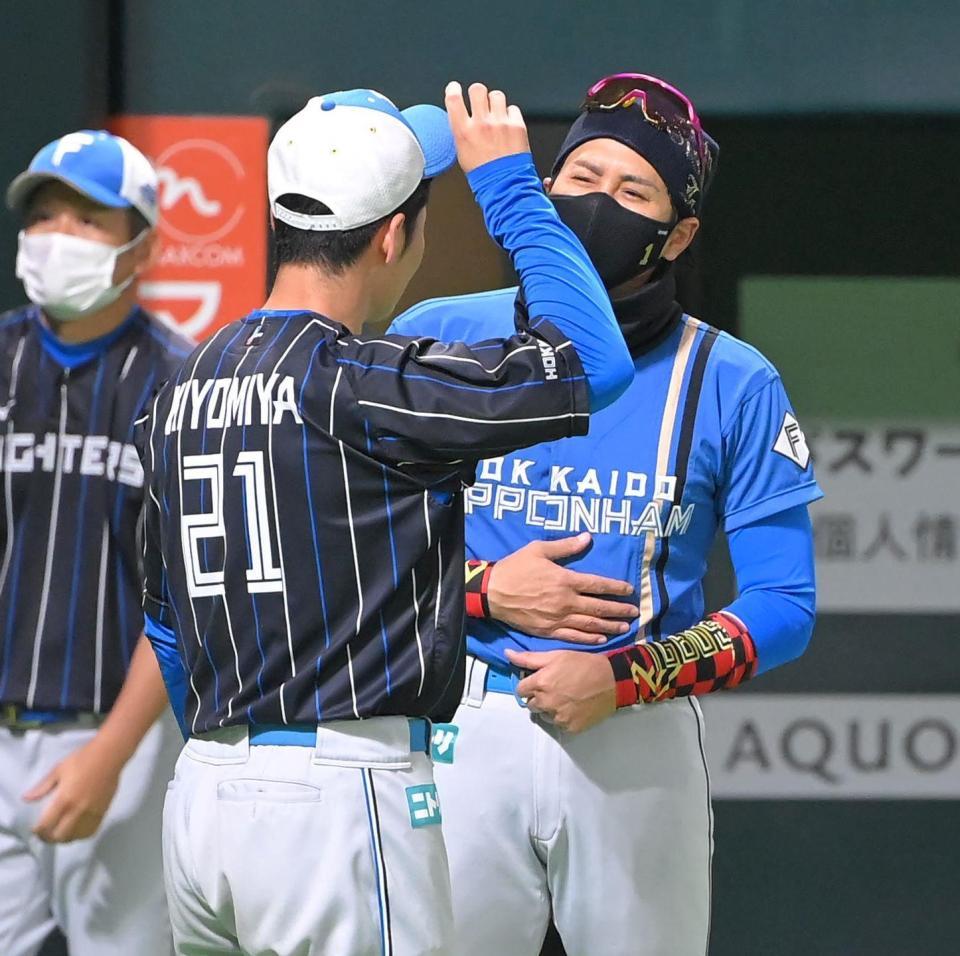 　前日の試合を胃腸炎で欠場した清宮（手前）とお腹を触りながら話す新庄ビッグボス（撮影・高部洋祐）