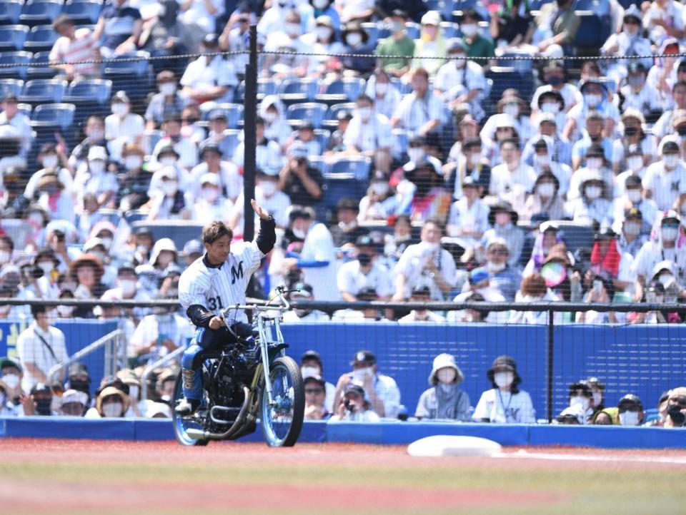 　始球式にバイクで登場しスタンドに手を振るオートレーサー青山周平（撮影・開出牧）