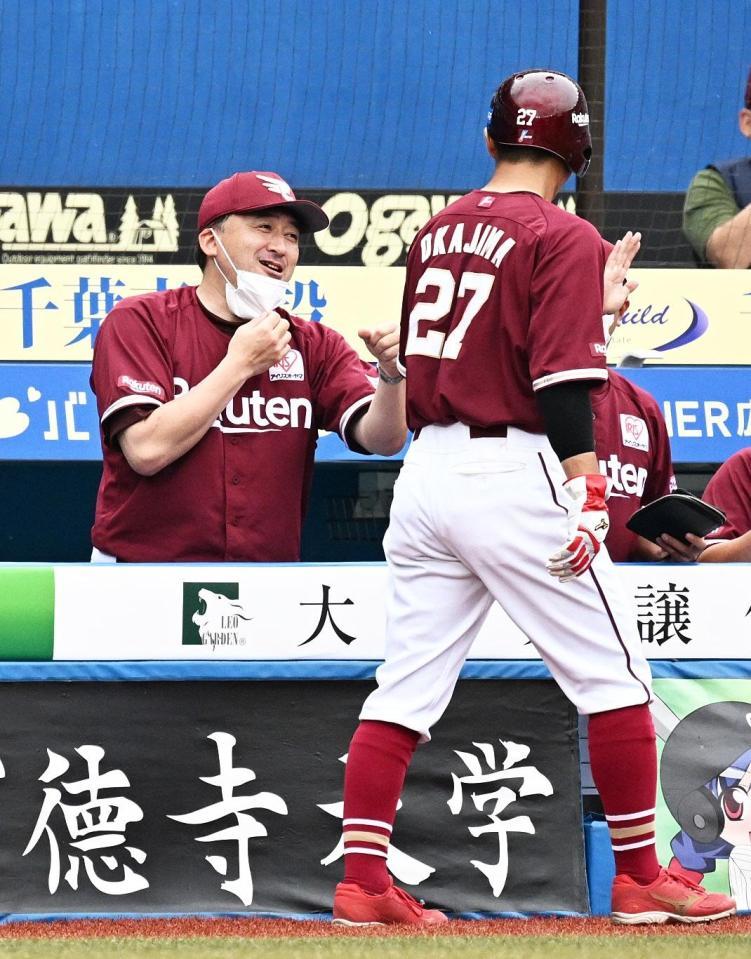 　５回表の攻撃を終え、ベンチに戻る岡島（右）らを笑顔で迎える石井監督