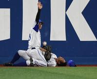 　８回、代打・伊藤の中飛をフェンスに激突しながら好捕しボールを離さず、もん絶する桑原（後方）。手前は左翼手・神里（撮影・開出牧）