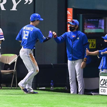 　５回、近藤の犠飛で生還した松本剛（左）を迎える新庄監督