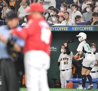 選手交代を告げる佐々岡監督（手前）の向こうで頭をかく原監督（撮影・西岡正）