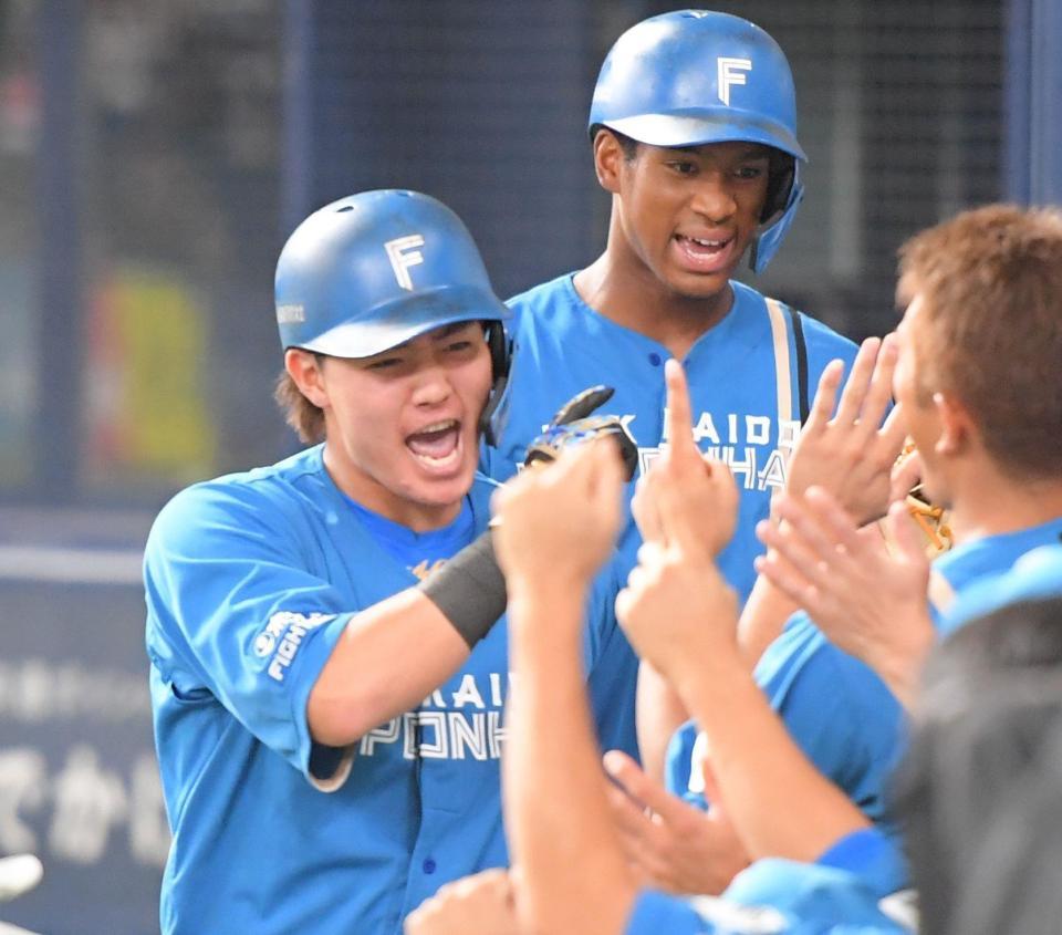 　５回、左越えに先制２ランを放ち、ナインとタッチを交わす郡（撮影・吉澤敬太）