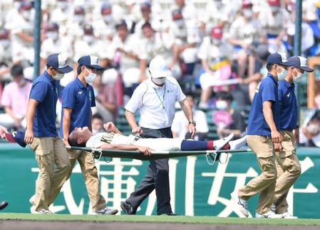 　７回、守備中に右足を痛め、顔をゆがめながら担架で運ばれる八戸学院光星の右翼手・深野