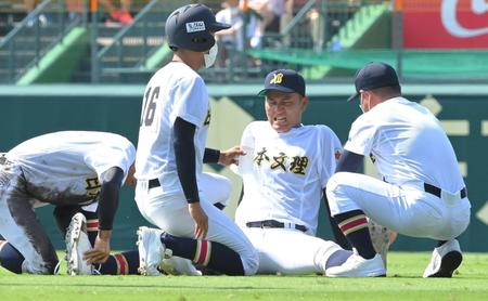 　６回途中、苦しそうに芝生に座り込む日本文理・玉木聖大（右から２人目）＝撮影・高部洋祐
