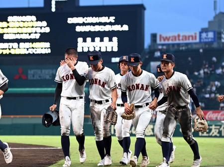 　サヨナラ死球を与えた興南・安座間（左）は号泣しながらナインとともに引き揚げる