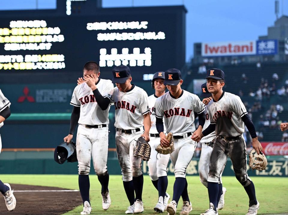 　サヨナラ死球を与えた興南・安座間（左）は号泣しながらナインとともに引き揚げる